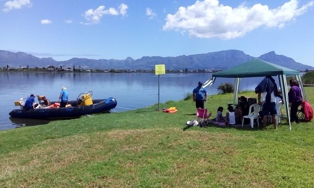 Floating picnic setup on boat with Cape Town coastline views